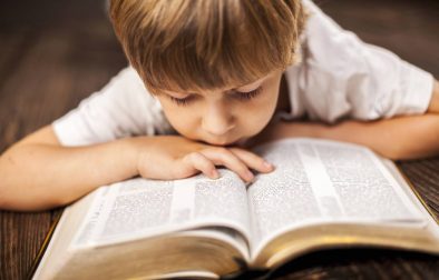 little boy studying the bible